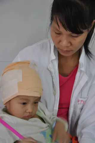 Đang Sang Nhà Hàng Xóm Chơi, Bé Na Bị Chó Cắn Làm Rách Toàn Bộ Vùng Da Đầu Khiến Máu Chảy Dầm Dề Buộc Em Phải Nhập Viện Trong Tình Trạng Khẩn Cấp. Việc Điều Trị Của Con Kéo Dài, Lại Tốn Kém Khiến Bố Mẹ Đứng Ngồi Không Yên Khi Mới Chỉ Đi Vay Được Vỏn Ven Mấy Triệu Đồng.